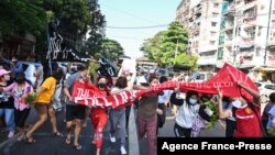 Protesters taking part in a demonstration against the military coup run as security forces launched a crackdown on the protest in Yangon, Myanmar, Dec. 5, 2021. 