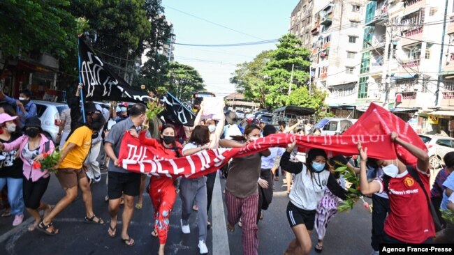 Protesters taking part in a demonstration against the military coup run as security forces launched a crackdown on the protest in Yangon, Myanmar, Dec. 5, 2021.