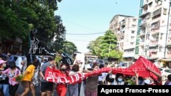 Protesters taking part in a demonstration against the military coup run as security forces launched a crackdown on the protest in Yangon, Myanmar, Dec. 5, 2021. 