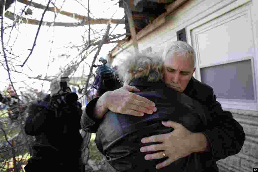 Indiana Gov. Mike Pence, right, hugs homeowner Patsy Addison in front of her storm damaged home in Kokomo, Indiana, Nov. 18, 2013. Dozens of tornadoes and intense thunderstorms swept across the U.S. Midwest, unleashing powerful winds that flattened entire neighborhoods, flipped over cars and uprooted trees.