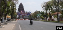 អ្នកដំណើរបើកបរម៉ូតូលើដងវិថីមួយ ក្នុងរាជធានីភ្នំពេញ ក្នុងអំឡុងពេលមានការឆ្លងជំងឺកូវីដ១៩ ក្នុងសហគមន៍លើកទីបី នៅរាជធានីភ្នំពេញប្រទេសកម្ពុជា កាលពីថ្ងៃទី២៤ ខែកុម្ភៈ ឆ្នាំ២០២១។ (ទុំ ម្លិះ/វីអូអេ)