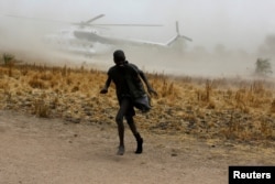 A boy moves away as a United Nations World Food Program helicopter lands in Rubkuai village, Unity State, northern South Sudan, Feb. 18, 2017.