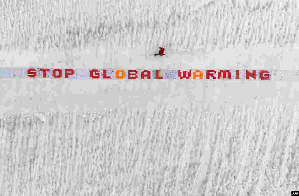 This aerial picture shows a giant roll of more than 2500 laminated postcards displayed for an exhibit test of an action against climate change, in the Aletsch Glacier near the Jungfraujoch in the Swiss Alps.