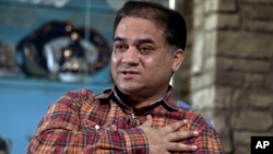 FILE - Ilham Tohti, an outspoken scholar of China's Turkic Uighur ethnic minority, speaks during an interview at his home in Beijing, China.