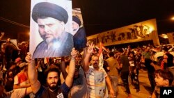 Followers of Shiite cleric Muqtada al-Sadr, seen in the posters, celebrate in Tahrir Square in Baghdad, Iraq, May 14, 2018. Iraq's electoral commission announced al-Sadr as the early front-runner.
