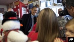 President Barack Obama visits patrons at We B Smokin' bar-b-que on the outskirts of Osawatomie, Kansas, Tuesday, Dec. 6, 2011.