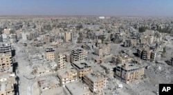 FILE - An image made from drone video shows damaged buildings in Raqqa, Syria, Oct. 19, 2017.