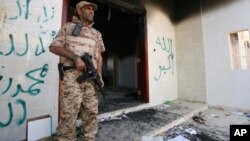 Un militar libio frente al consulado atacado en Bengasi donde murió el embajador estadounidense Chris Stevens.