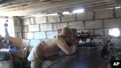 지난해 7월 시리아 데이르 엘 조르 지역에서 이슬람 수니파 무장단체 ISIL 조직원이 정부군과 전투 중 총을 조준하고 있다. (자료사진) 