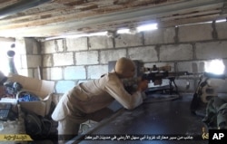 FILE - This file picture released on July 13, 2015 by the Rased News Network, a Facebook page affiliated with Islamic State militants, shows an Islamic State militant sniper in position during a battle against Syrian government forces, in Deir el-Zour pro