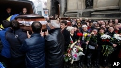 People carry the coffin of Bogdan Solchunuk, in front of the St. Paul and Peter church, during his funeral, in Lviv, western Ukraine, Feb. 22, 2014.
