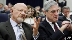 Director for National Intelligence James Clapper, left, and FBI Director Robert Mueller, talk during the launch of the Strategy to Combat Transnational Organized Crime, Monday, July 25, 2011.