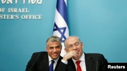 FILE - Israeli Prime Minister Benjamin Netanyahu (R) and Finance Minister Yair Lapid smile during a joint news conference in Jerusalem, July 2013.