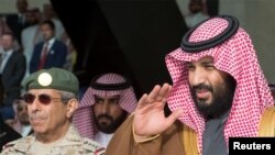 محمد بن سلمان، ولیعهد عربستان سعودی که وزیر دفاع آن کشور است، در یک مراسم فارغ التحصیلی در دانشگاه هوایی ملک فیصل در ریاض سلام نظامی می دهد. ۲۱ فوریه ۲۰۱۸