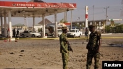 Members of the military stand at the scene of an explosion near a petrol station in Kano, Nigeria, Nov. 15, 2014. 