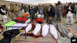 Bodies of victims killed from Sunday's suicide attack are laid on the ground in the Yahyakhail district of Paktika province east of Kabul, Afghanistan, Nov. 24, 2014.