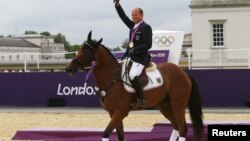 Germany's Michael Jung celebrates his gold medal on his horse Sam during the Eventing Individual Jumping equestrian final victory ceremony at the London 2012 Olympic Games in Greenwich Park, July 31, 2012. REUTERS/Eddie Keogh (BRITAIN - Tags: SPORT O