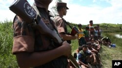 မြန်မာ ဘင်္ဂလားဒေ့ရှ်နယ်စပ်မှာ ဘင်္ဂလားဒေ့ရှ် လုံခြုံရေးတပ်ဖွဲ့များ မြန်မာဘက်က ထွက်ပြေးလာသူတွေကို ထိန်းသိမ်းထားစဉ်။ (သြဂုတ်လ ၂၇-၂၀၁၇)