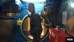 A sailor navigates the narrow passageways of the USS Alaska, one of the Navy's Ohio-class submarines.(C. Babb/VOA)