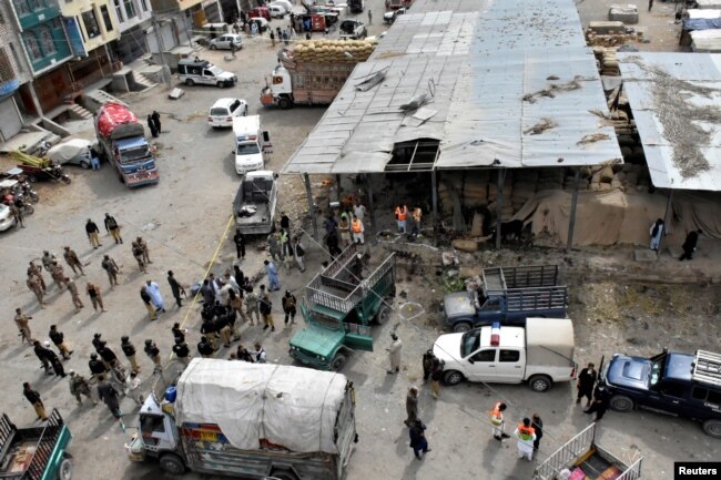 FILE - Rescue workers and army soldiers gather at the site of a blast at a vegetable market in Quetta, Pakistan, April 12, 2019.