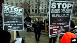 Demonstrators hold banners as they protest in opposition of President-elect Donald Trump, at McPherson Square, in Washington, Jan. 14, 2017. 