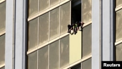 FILE - Workers board up a broken window at the Mandalay Bay hotel, where shooter Stephen Paddock conducted his mass shooting along the Las Vegas Strip, in Las Vegas, Nevada, Oct. 6, 2017.