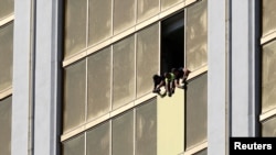 FILE: Workers board up a broken window at the Mandalay Bay hotel, where shooter Stephen Paddock conducted his mass shooting along the Las Vegas Strip, in Las Vegas, Nevada, U.S., Oct. 6, 2017. 