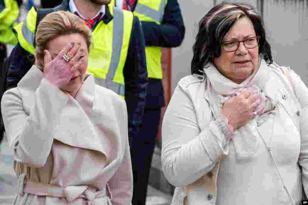 People react as they walk away from Brussels airport after explosions rocked the facility in Brussels, Belgium March 22, 2016. 