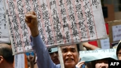 A demonstrator shouts during a protest to denounce the governments voting system outside the venue where a 1,200-member election committee are to choose the city's new leader, in Hong Kong, March 25, 2012. 