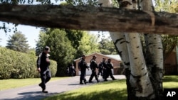 Corrections officers walk through a residential area in Malone, N.Y., during a search for two escaped prisoners from the Clinton Correctional Facility, June 24, 2015,