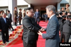 FILE - South Korean President Moon Jae-in shakes hands with North Korean leader Kim Jong Un during their summit at the truce village of Panmunjom, North Korea, May 27, 2018.