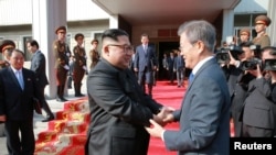 Le président sud-coréen Moon Jae-in serre avec le dirigeant nord-coréen Kim Jong Un à Panmunjom, en Corée du Nord, le 27 mai 2018.