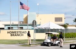 Security guards stand outside a former Job Corps site that now houses child immigrants, June 18, 2018, in Homestead, Florida.