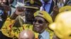 In this file photo taken on Nov. 8, 2017, Zimbabwe's then-President Robert Mugabe raises his fist as he greets party members and supporters gathered at his party headquarters. 
