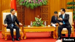 Chinese State Councilor Yang Jiechi (L) listens to Vietnamese Prime Minister Nguyen Tan Dung in Hanoi, June 18, 2014.