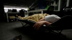 A system engineer at RenRen Credit Management Co., sleeps on a camp bed at the office