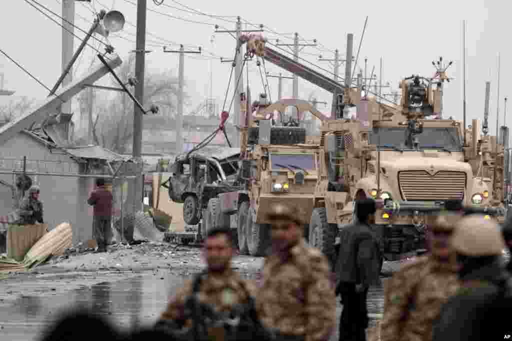 Afghan police and NATO forces respond to a suicide car bomb attack on the Jalalabad-Kabul road in Kabul, Afghanistan, Dec. 27, 2013.