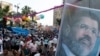 FILE - Members of the Muslim Brotherhood and supporters of deposed Egyptian President Mohamed Morsi hold a giant poster bearing his image at a protest in Cairo's Rab'a al-Adawiya Square, Aug. 8, 2013.