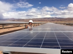 FILE - Guillermo Giralt, technical director of Cauchari Solar, stands next to solar panels at a solar farm, built on the back of funding and technology from China, in Salar de Cauchari, Argentina, April 3, 2019.