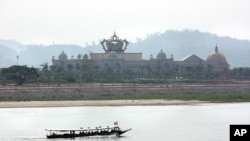 FILE - A boat on the Mekong River passes Chinese-run Kings Roman Casino in the special economic zone in Laos. (D. Schearf/VOA)