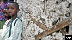 Bé trai Endashew và em gái Yeshiwork, mất cả cha lẫn mẹ vì HIV/AIDS ngồi trước căn nhà ở gần thủ đô Addis Ababa, Ethiopia