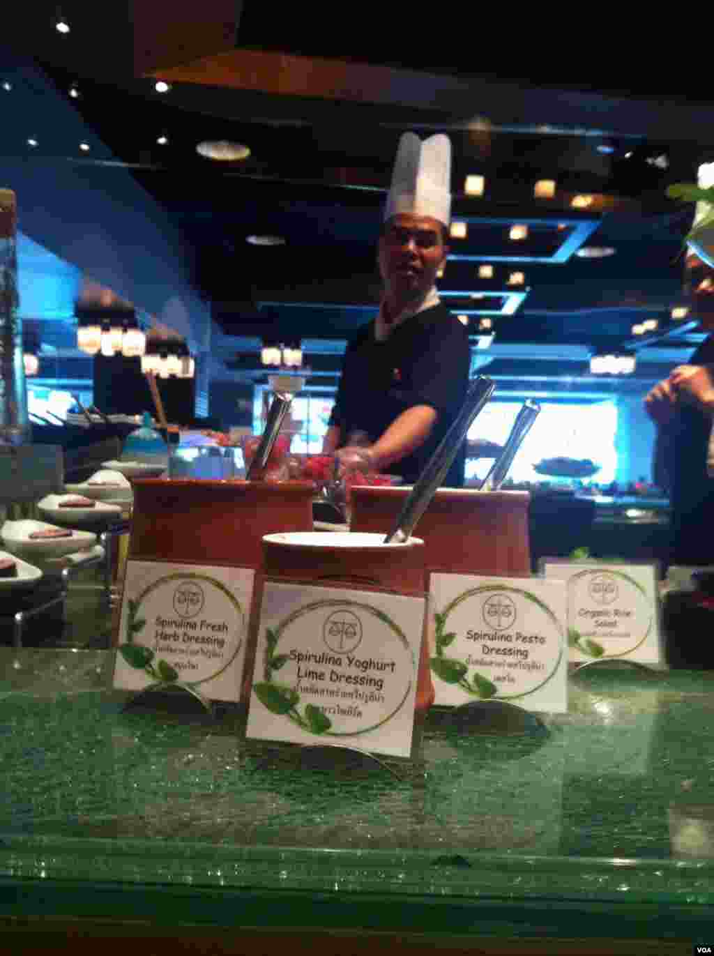 Salad dressings are among the items made from fresh spirulina at the buffet in a restaurant at the Novotel on Siam Square in Bangkok, Sept. 23, 2013. (S.L. Herman/VOA)