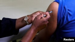 FILE - A healthcare worker administers the Pfizer coronavirus disease (COVID-19) vaccine to a man, amidst the spread of the SARS-CoV-2 variant Omicron, in Johannesburg, South Africa, Dec. 9, 2021.