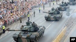 Tanks roll on one of the city's main streets during a yearly military parade celebrating the Polish Army Day in Warsaw, Poland, Aug. 15, 2018. 
