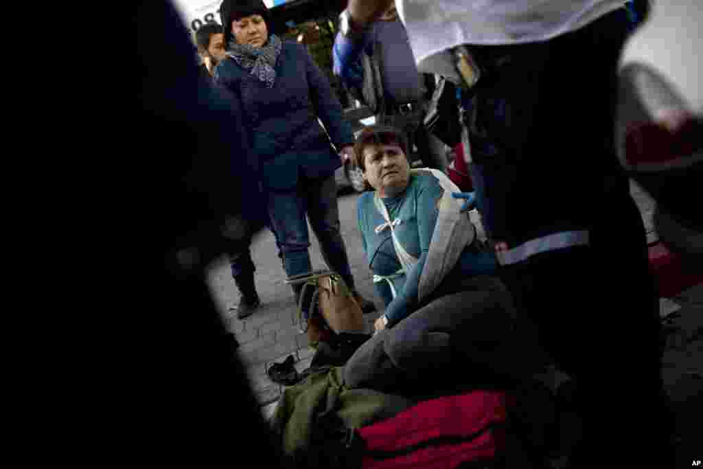 Israeli paramedics treat an injured woman at the scene of a stabbing in Tel Aviv, Jan. 21, 2015.