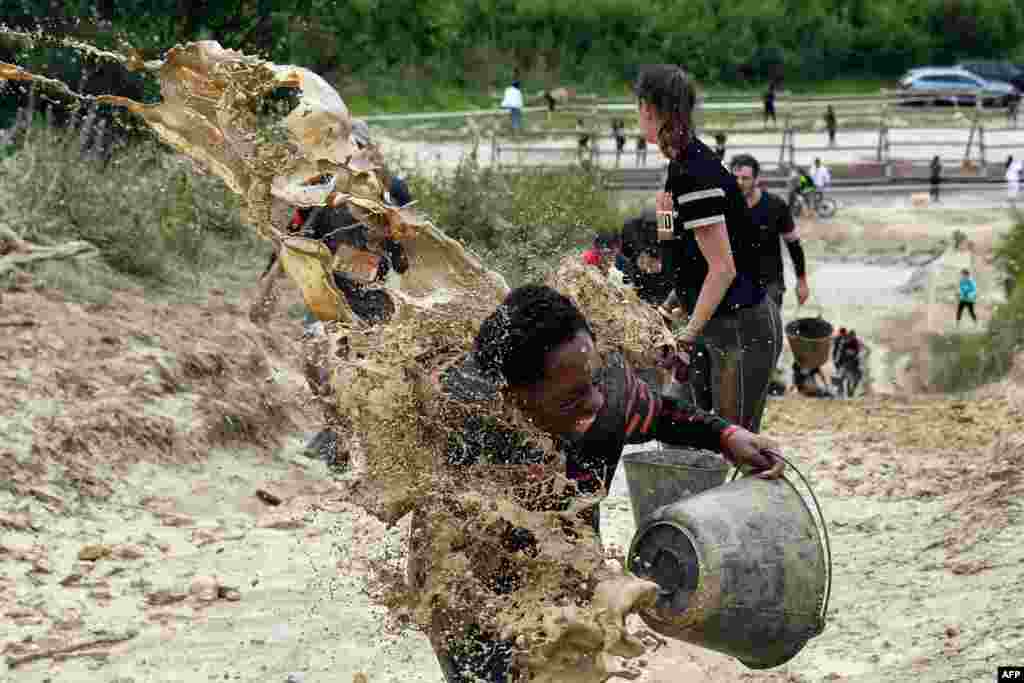 Mud is thrown at runners as they take part in the Mud Day, a 13-kilometer race in Beynes, near Paris, France, June 16, 2019.