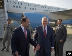 U.S. Secretary of State Rex Tillerson chats with Pakistani foreign office official, Sajid Bilal, as he arrives to the Nur Khan military airbase in Islamabad, Pakistan, Oct. 24, 2017.
