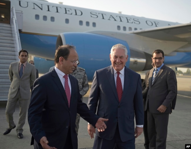 U.S. Secretary of State Rex Tillerson chats with Pakistani foreign office official, Sajid Bilal, as he arrives to the Nur Khan military airbase in Islamabad, Pakistan, Oct. 24, 2017.