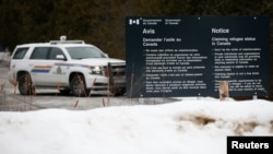 FILE - A Royal Canadian Mounted Police (RCMP) vehicle is seen near a sign at the US-Canada border in Lacolle, Quebec, Canada, Feb. 14, 2018.