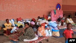 FILE: Migrant and refugee families sit on the floor in the makeshift camp on the Place de la Republique in Mamoudzou, the capital of Mayotte on June 16, 2016 after groups of residents organized several operations of expulsion in various towns since January 2016.
